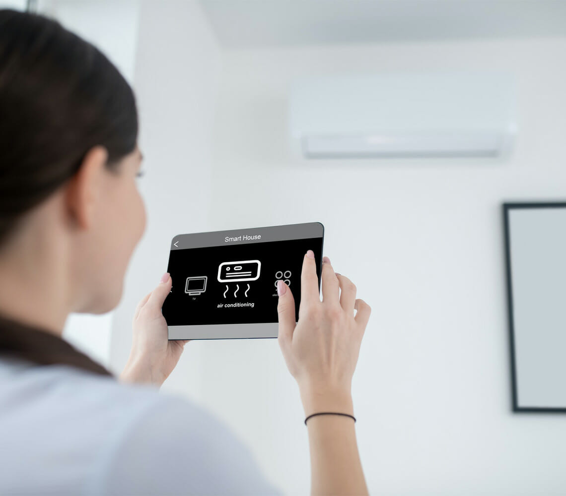 woman turning on an air conditioning unit